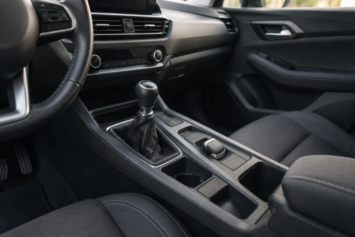Console of a used car showing a parking brake lever and an electric switch as alternatives.