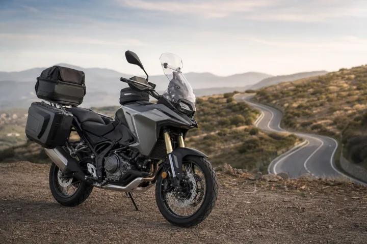 Moto de carretera estacionada con maletas laterales, una maleta trasera y una bolsa de depósito para un viaje